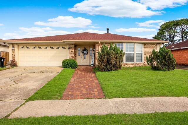 ranch-style house featuring concrete driveway, a front yard, an attached garage, and brick siding