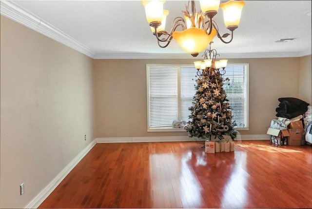 unfurnished dining area with crown molding, hardwood / wood-style floors, and a chandelier