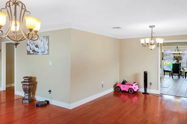 dining area with a chandelier, wood finished floors, baseboards, and crown molding