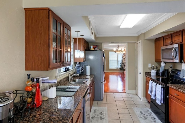 kitchen featuring appliances with stainless steel finishes, hanging light fixtures, crown molding, and plenty of natural light