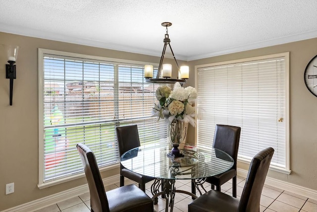 dining space featuring a textured ceiling, light tile patterned flooring, ornamental molding, and a notable chandelier