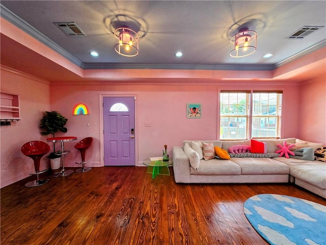 living room featuring wood-type flooring, ornamental molding, and a raised ceiling