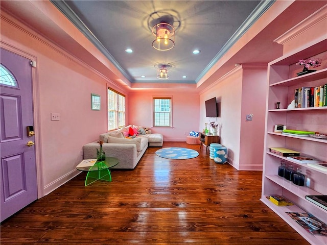 living room with crown molding, a tray ceiling, and dark hardwood / wood-style floors