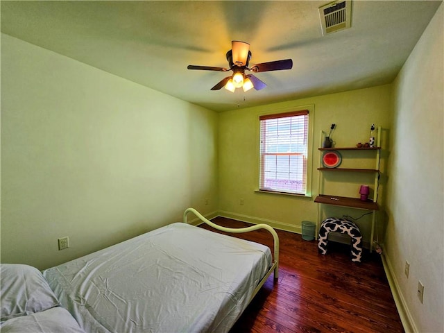 bedroom with dark hardwood / wood-style flooring and ceiling fan