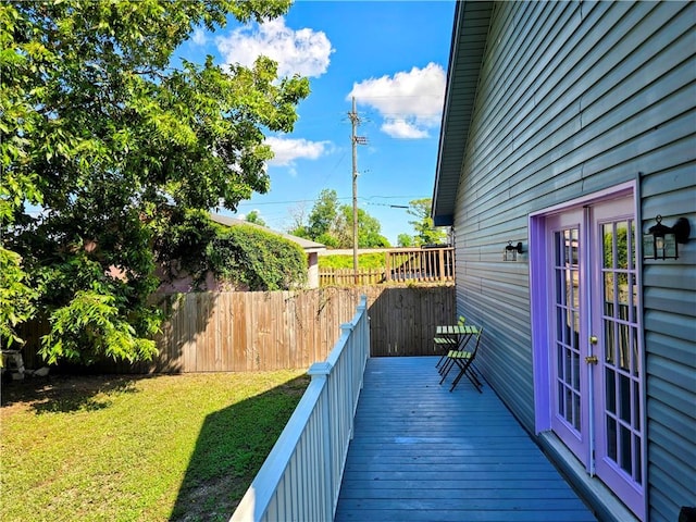 wooden terrace with french doors and a yard