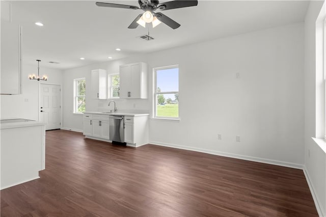 kitchen featuring dark hardwood / wood-style flooring, white cabinetry, stainless steel dishwasher, and a wealth of natural light