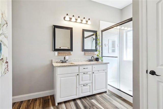 bathroom with hardwood / wood-style floors, an enclosed shower, and vanity