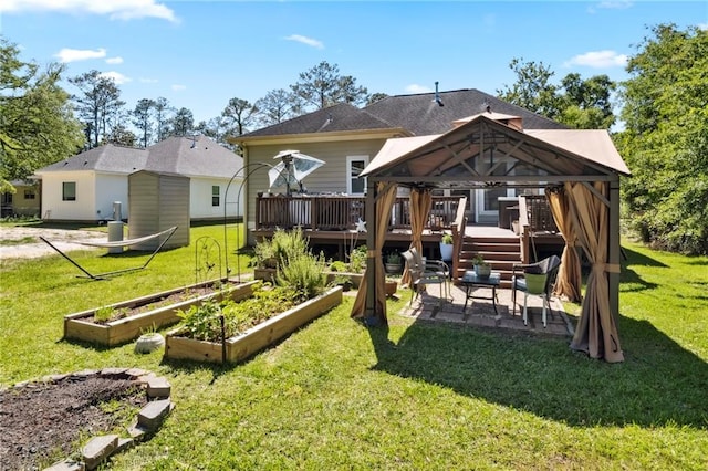 rear view of property with a wooden deck, a patio, a gazebo, and a yard