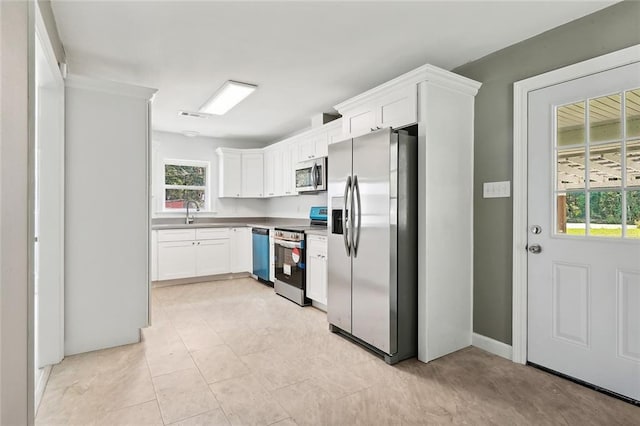 kitchen with white cabinetry, visible vents, stainless steel appliances, and a sink