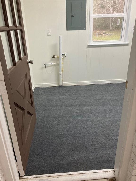 laundry area with carpet, electric panel, and baseboards