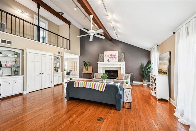 living room featuring track lighting, ceiling fan, beam ceiling, high vaulted ceiling, and light hardwood / wood-style floors