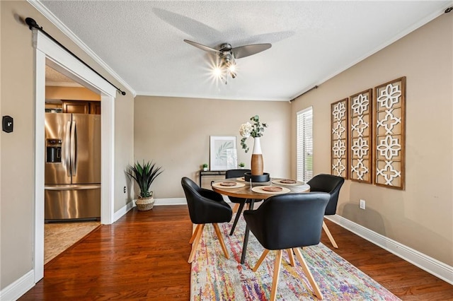 dining area with a textured ceiling, dark hardwood / wood-style flooring, ceiling fan, and crown molding