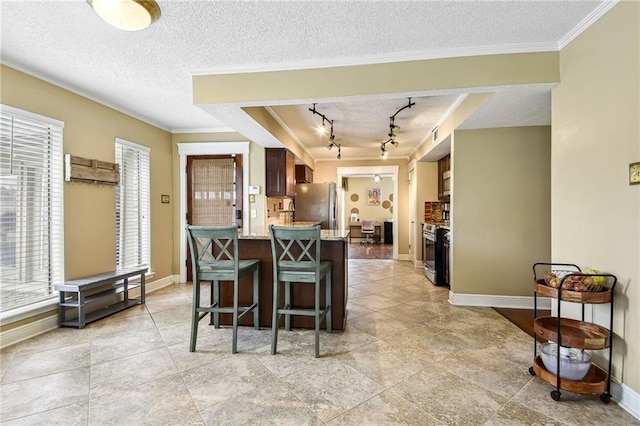 kitchen featuring a textured ceiling, stainless steel appliances, and ornamental molding