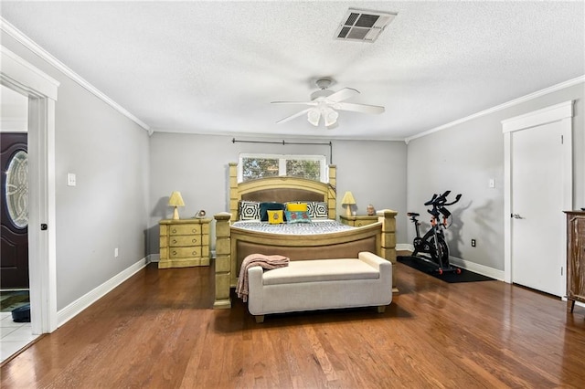 bedroom featuring a textured ceiling, ceiling fan, dark hardwood / wood-style floors, and ornamental molding