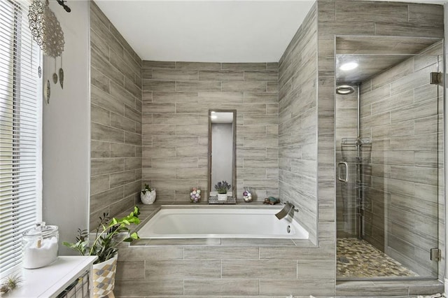 bathroom featuring separate shower and tub