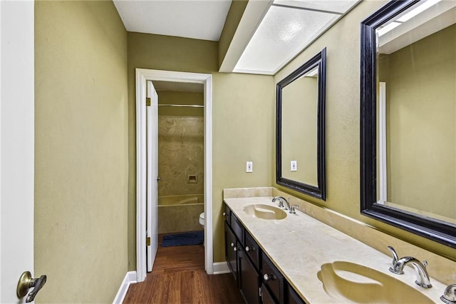 full bathroom with hardwood / wood-style floors, vanity, toilet, and shower / bathtub combination