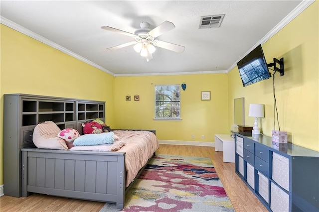 bedroom featuring hardwood / wood-style flooring, ceiling fan, and crown molding