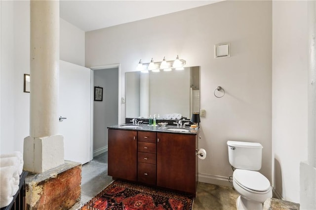 bathroom with concrete flooring, vanity, and toilet