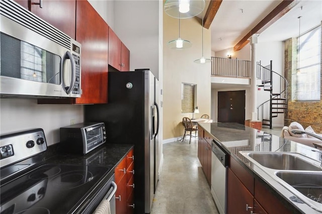 kitchen featuring pendant lighting, sink, beam ceiling, stainless steel appliances, and a high ceiling