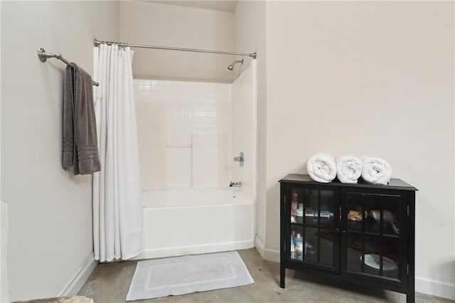 bathroom featuring concrete flooring and shower / bath combo with shower curtain