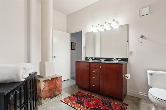 bathroom featuring vanity, concrete floors, and toilet