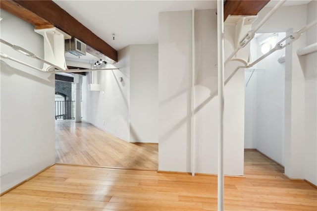 walk in closet featuring beam ceiling and hardwood / wood-style floors