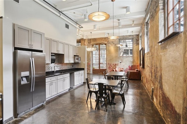 kitchen with pendant lighting, sink, gray cabinets, stainless steel appliances, and tasteful backsplash