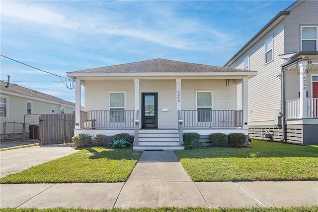 bungalow-style home featuring covered porch and a front yard