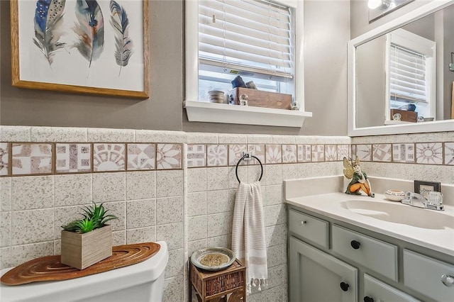 bathroom featuring tile walls, vanity, and toilet