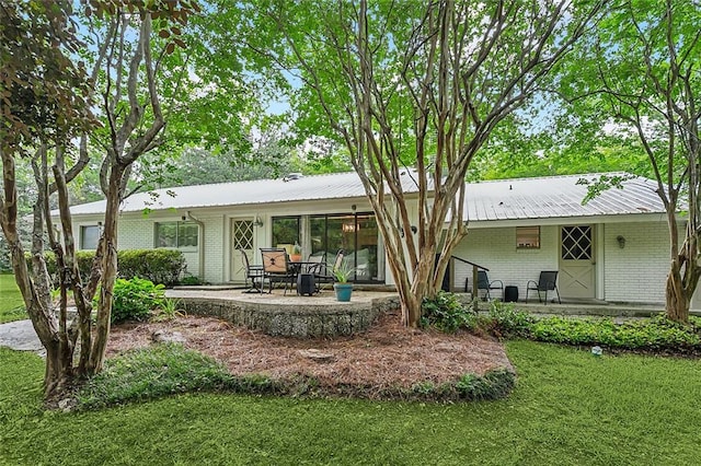 rear view of house with a yard and a patio area