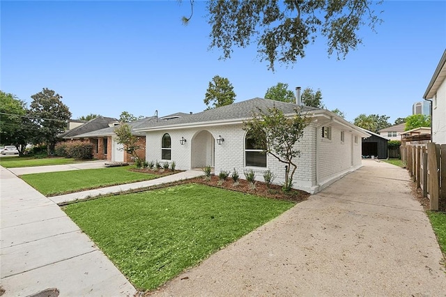 ranch-style house featuring a garage and a front lawn