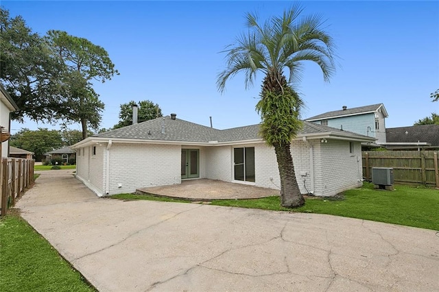 back of house featuring a lawn, a patio, and central air condition unit