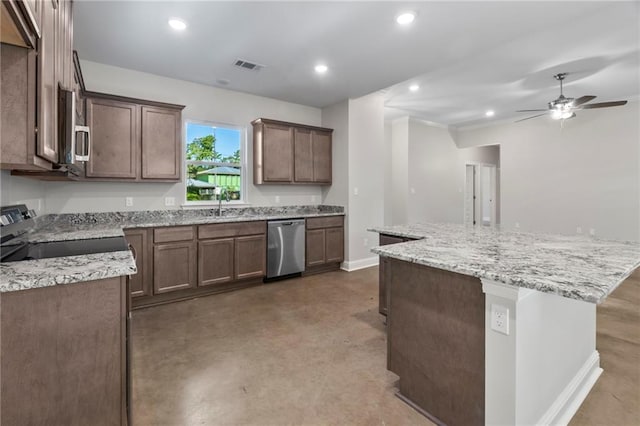 kitchen with light stone counters, ceiling fan, a kitchen island, concrete flooring, and stainless steel appliances