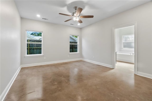 unfurnished room with ceiling fan, concrete flooring, and a healthy amount of sunlight