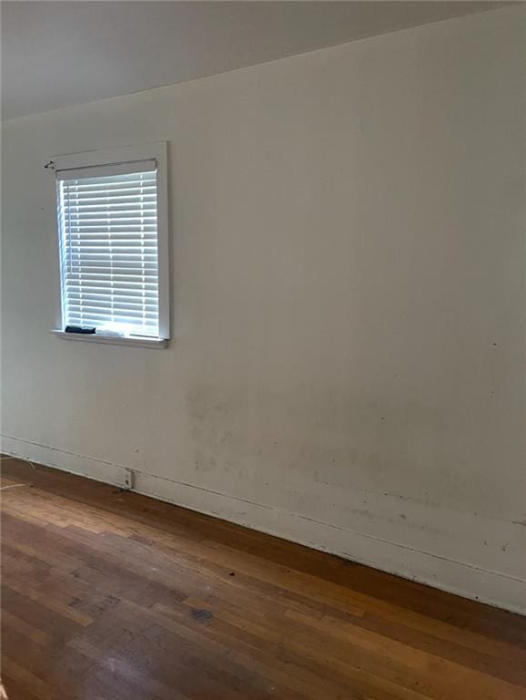 unfurnished room with dark wood-type flooring