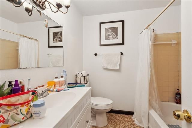 full bathroom with shower / tub combo with curtain, tile patterned floors, vanity, and toilet