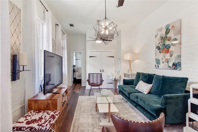 living room featuring a notable chandelier and dark hardwood / wood-style flooring