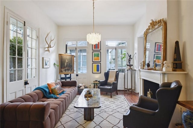 living room featuring an inviting chandelier, light hardwood / wood-style floors, and a healthy amount of sunlight