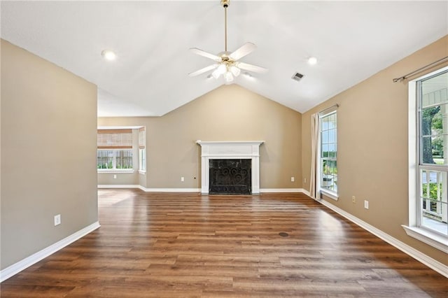 unfurnished living room with ceiling fan, vaulted ceiling, a premium fireplace, and dark wood-type flooring