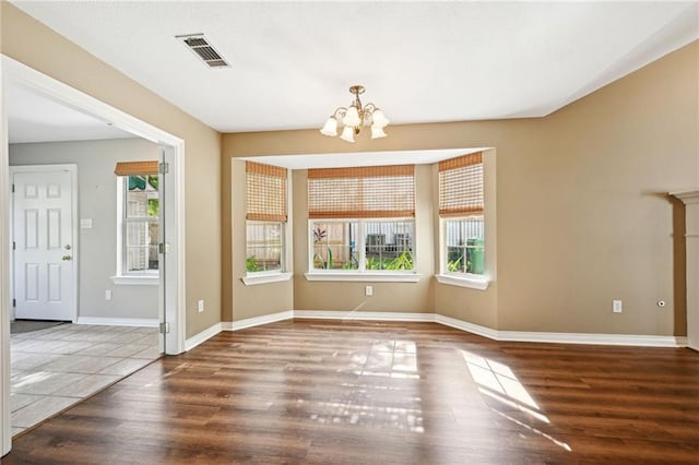 unfurnished dining area featuring a notable chandelier and dark hardwood / wood-style flooring