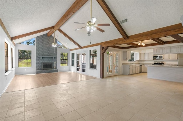 unfurnished living room with a textured ceiling, ceiling fan, sink, light hardwood / wood-style flooring, and a fireplace