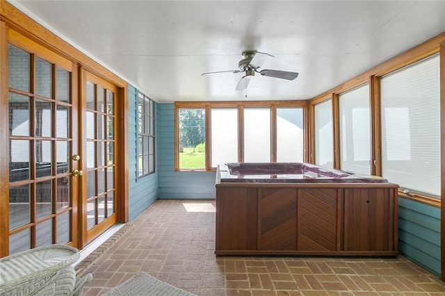 unfurnished sunroom featuring a hot tub and ceiling fan