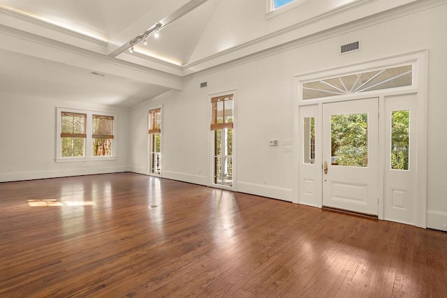 foyer with lofted ceiling, dark wood-type flooring, ornamental molding, and rail lighting