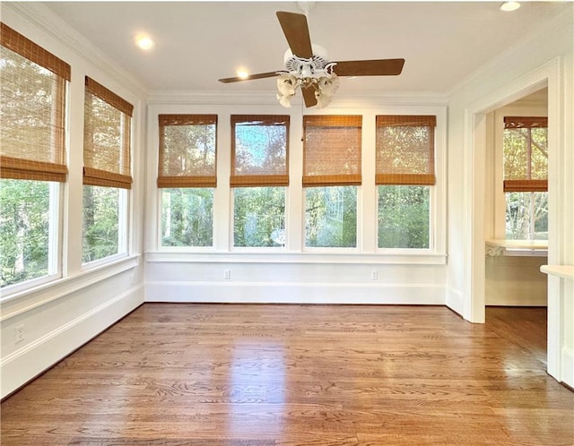 unfurnished sunroom featuring ceiling fan and plenty of natural light