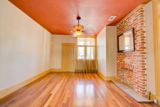 empty room featuring light wood-type flooring and a textured ceiling