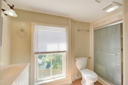 bathroom featuring an enclosed shower, vanity, and toilet