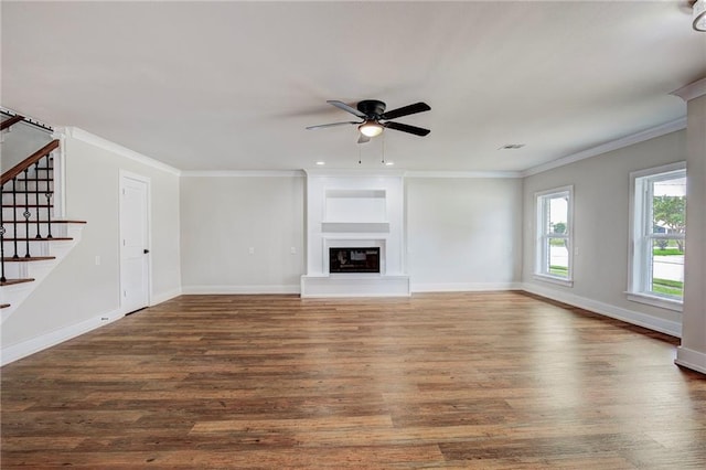 unfurnished living room with ceiling fan, ornamental molding, and dark wood-type flooring