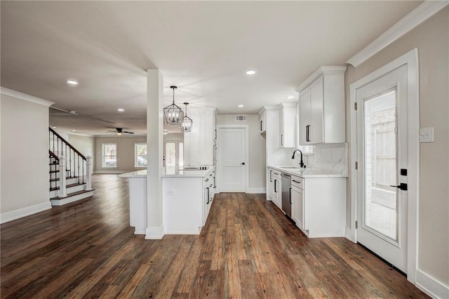 kitchen featuring white cabinetry, stainless steel dishwasher, sink, and dark hardwood / wood-style flooring