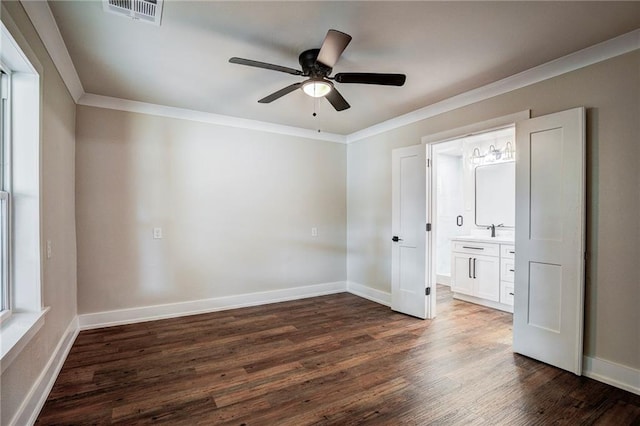 unfurnished bedroom with ornamental molding, ensuite bath, ceiling fan, and dark wood-type flooring