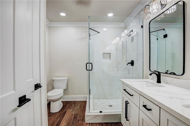 bathroom featuring vanity, an enclosed shower, hardwood / wood-style floors, and toilet